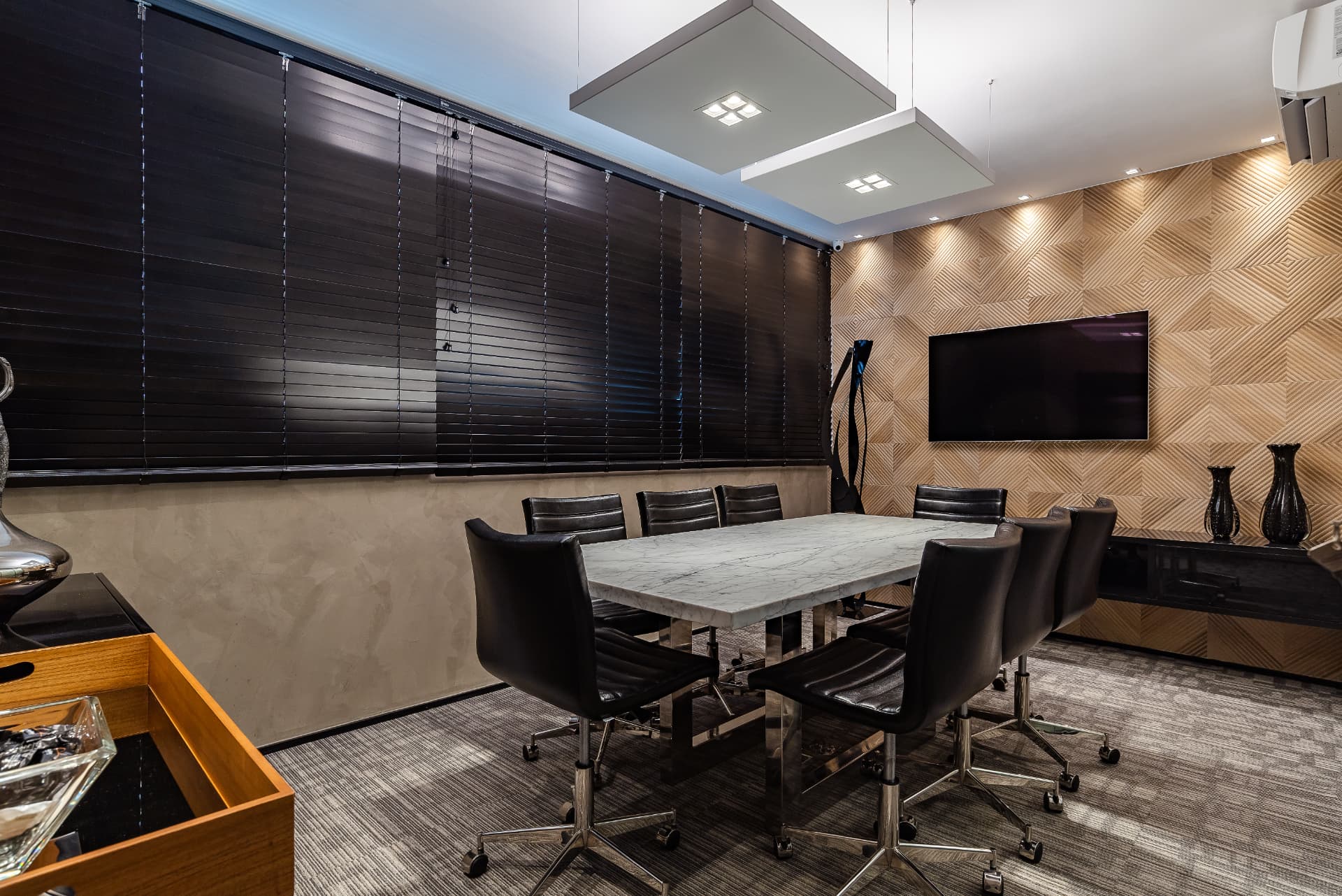 Sala de reuniões com mesa de mármore e televisor